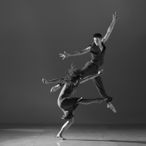 This is a black and white image of a woman kicking and a man jumping.