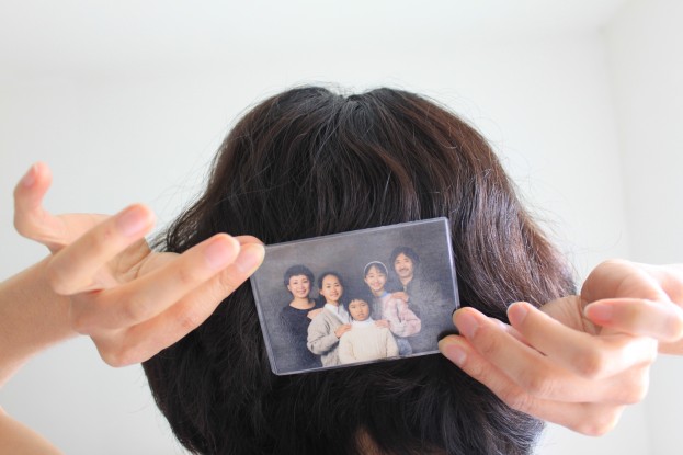 hands hold family photo behind head