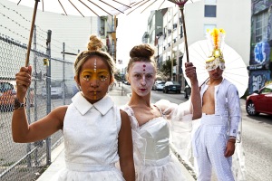 Group of dancers in white costumes holding umbrellas