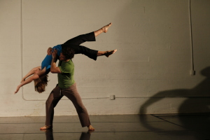 A female dancer is lifted by a male dancer