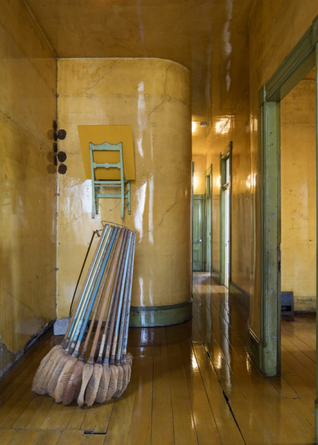 yellow hallway with brooms strung together