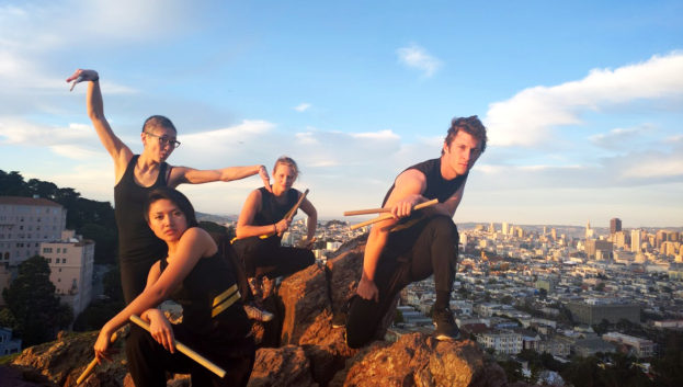 four dancers perch on Corona Hill overlooking San Francisco