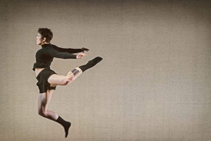 dancer leaps mid-air with one leg behind