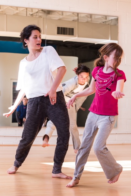 Dance teacher moving with younger student