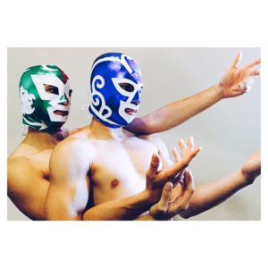 Two half naked male dancers wearing luchadores masks