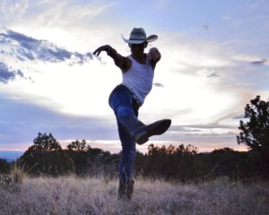 Cowboy dressed dancer lift hip and flicking wrists