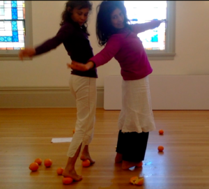 Two dancers standing on oranges