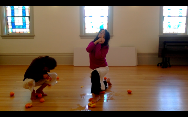 Two dancers peeling oranges