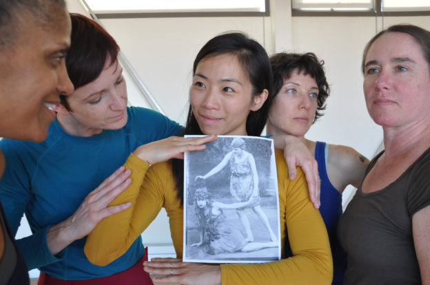 Five women holding an historic photograph