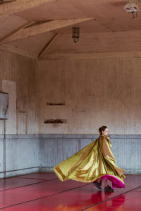 Dancer in giant gold shawl twirling