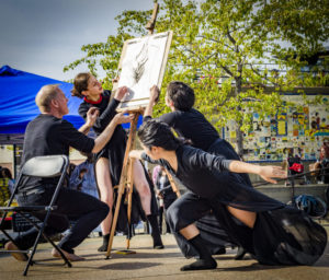 Three dancers performing outdoors with a visual artist 
