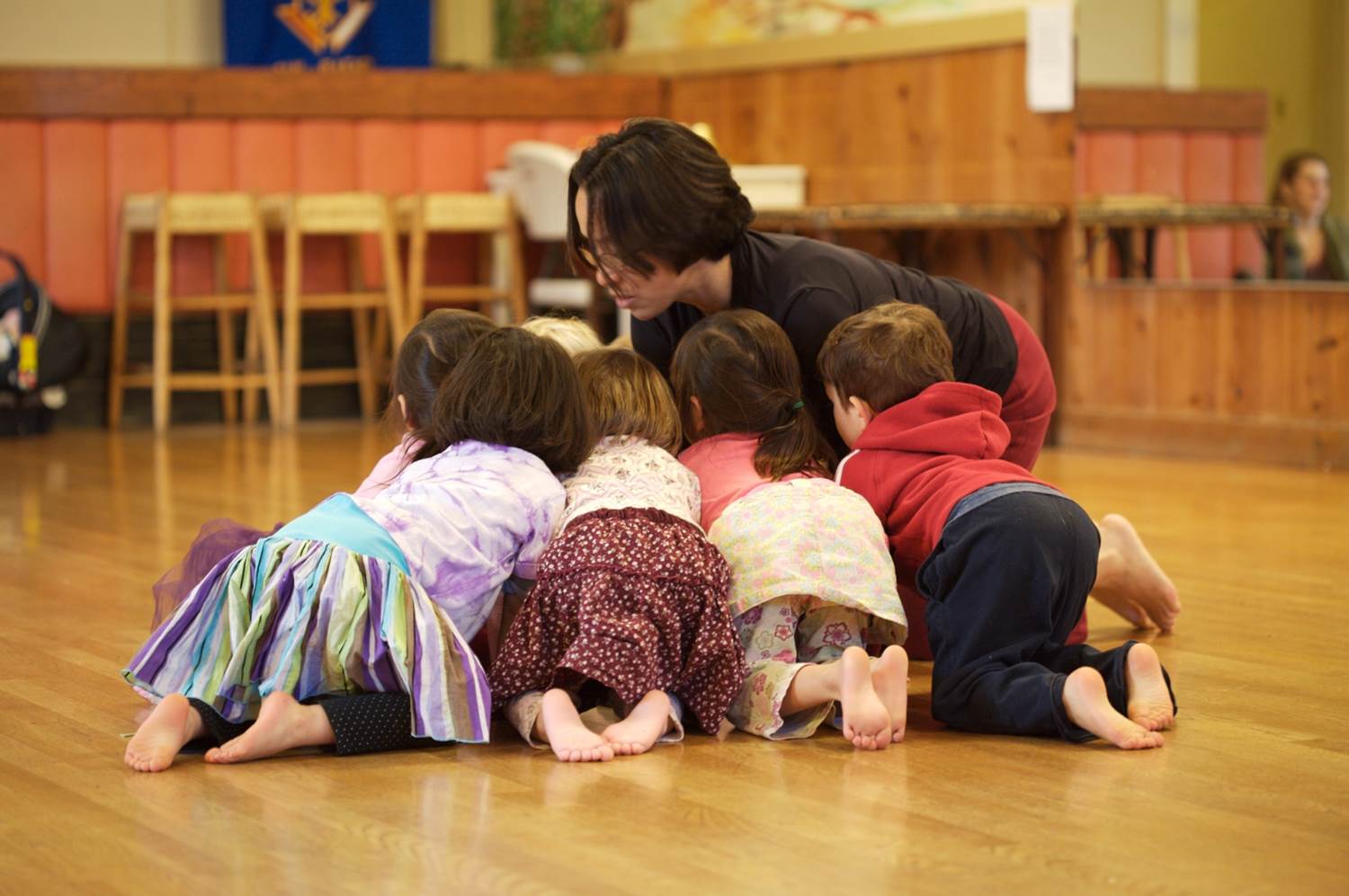 Group of children in a close circle on a studio floor