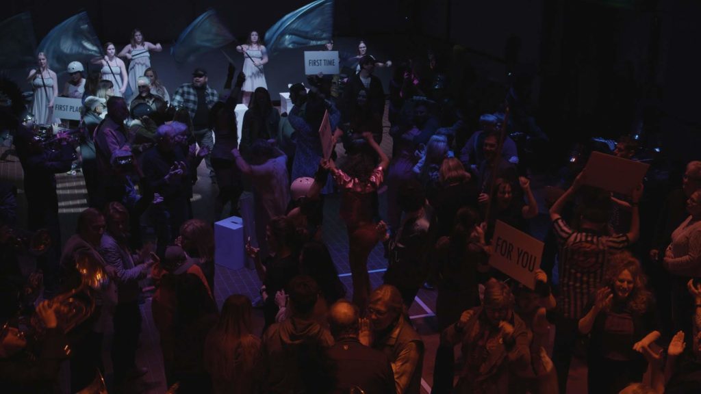 audience and performers in a dark blue room