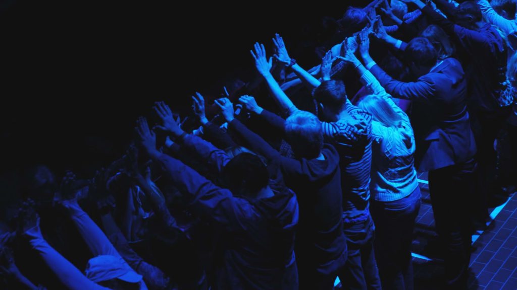 audience of people in dark blue lighting