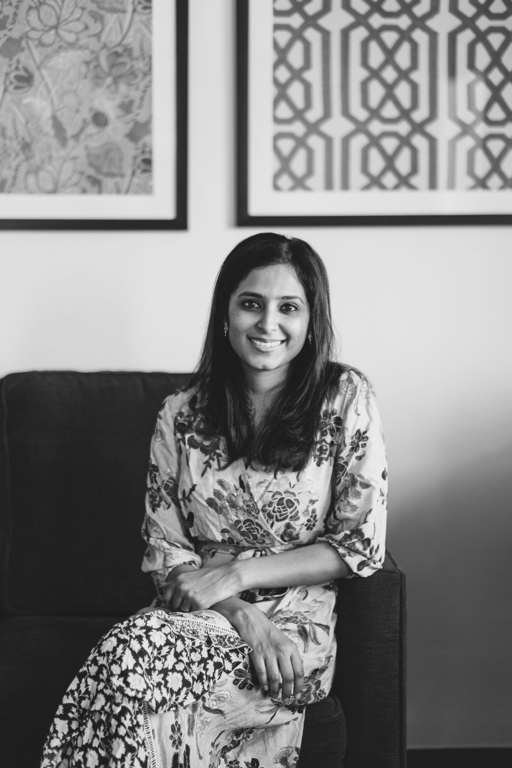 Black and white photo of Preethi Ramaprasad sitting on a couch
