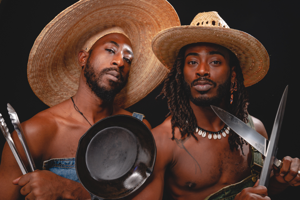 Two Black men wearing straw hats.