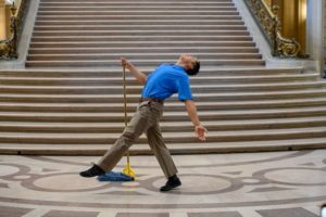 Melecio Estrella dancing as a Janitor with a mop in the Rotunda of San Francisco City Hall