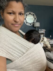 Danielle holding her baby in a wrap.