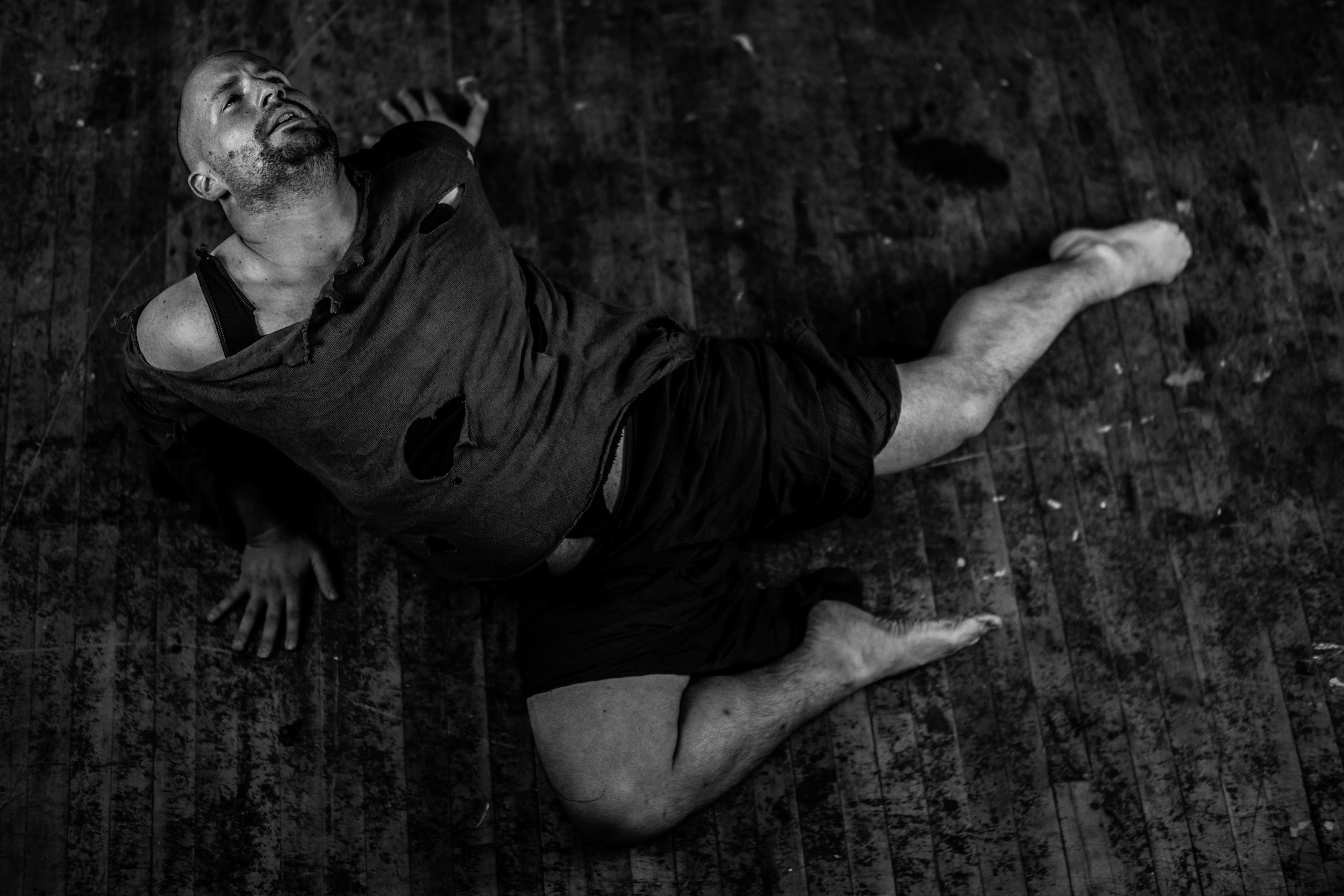 Black and white photo of dancer laying on wooden floor