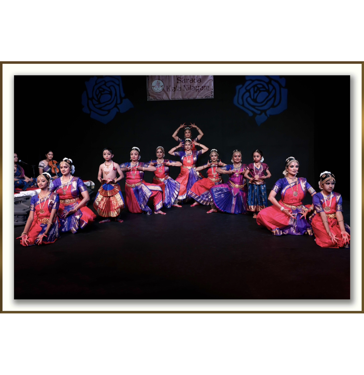 Many child dancers pose side by side in traditional costumes