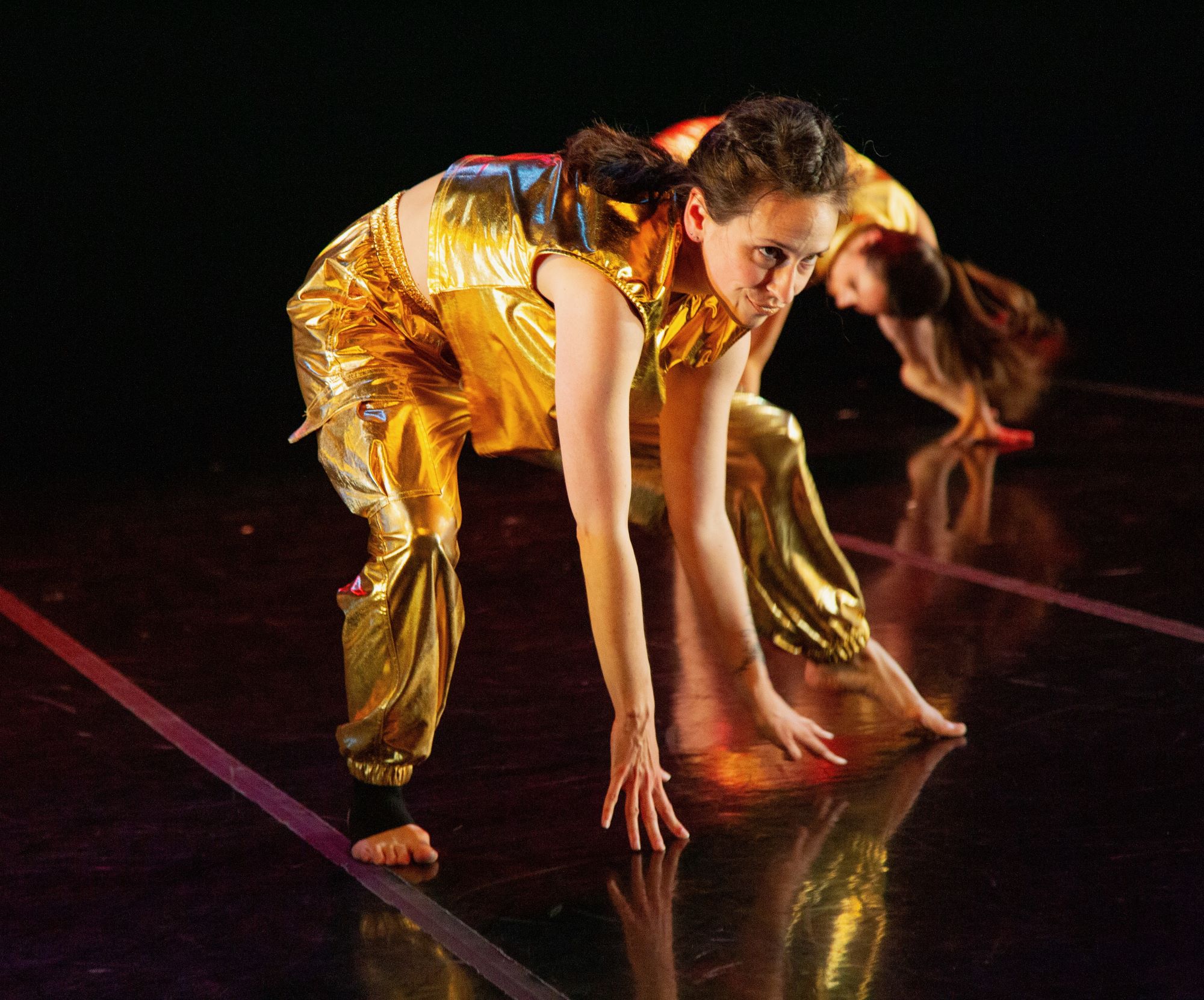 Dancer in gold with dancer behind her