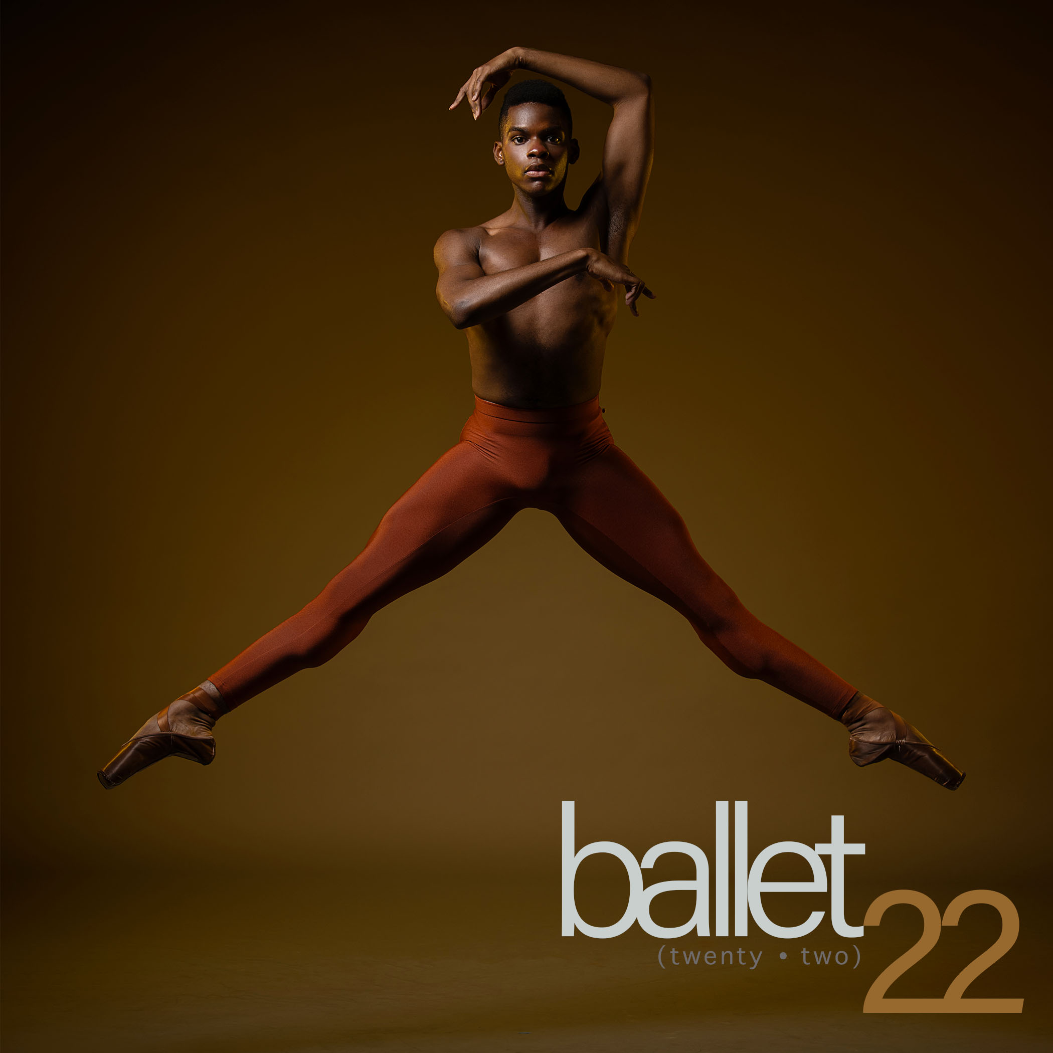 Image of Ballet22 dancer Daniel R Durrett jumps in orange tights and flesh tone pointe shoes
