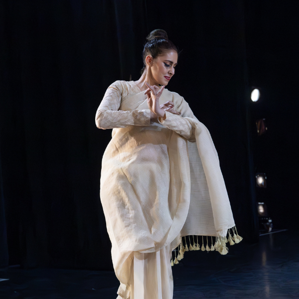 Leela Dance Theater Main Image of a woman in white cloth with her hands crossed in a dancing pose.