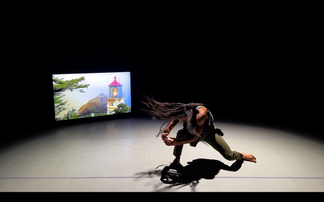 A black man with green pants and long braids is lunging towards the center of a white pool of downlight.