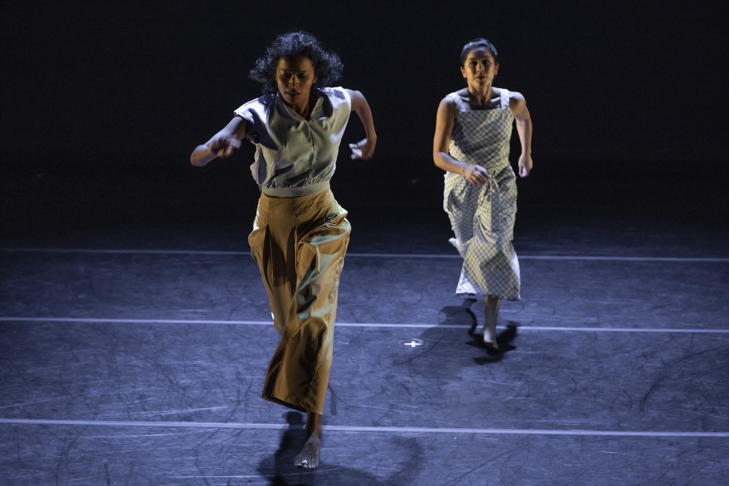 Two women dancers running toward the camera.