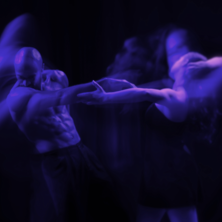 Two dancers move away from each other, lit in blue light, with a blue streak of movement.