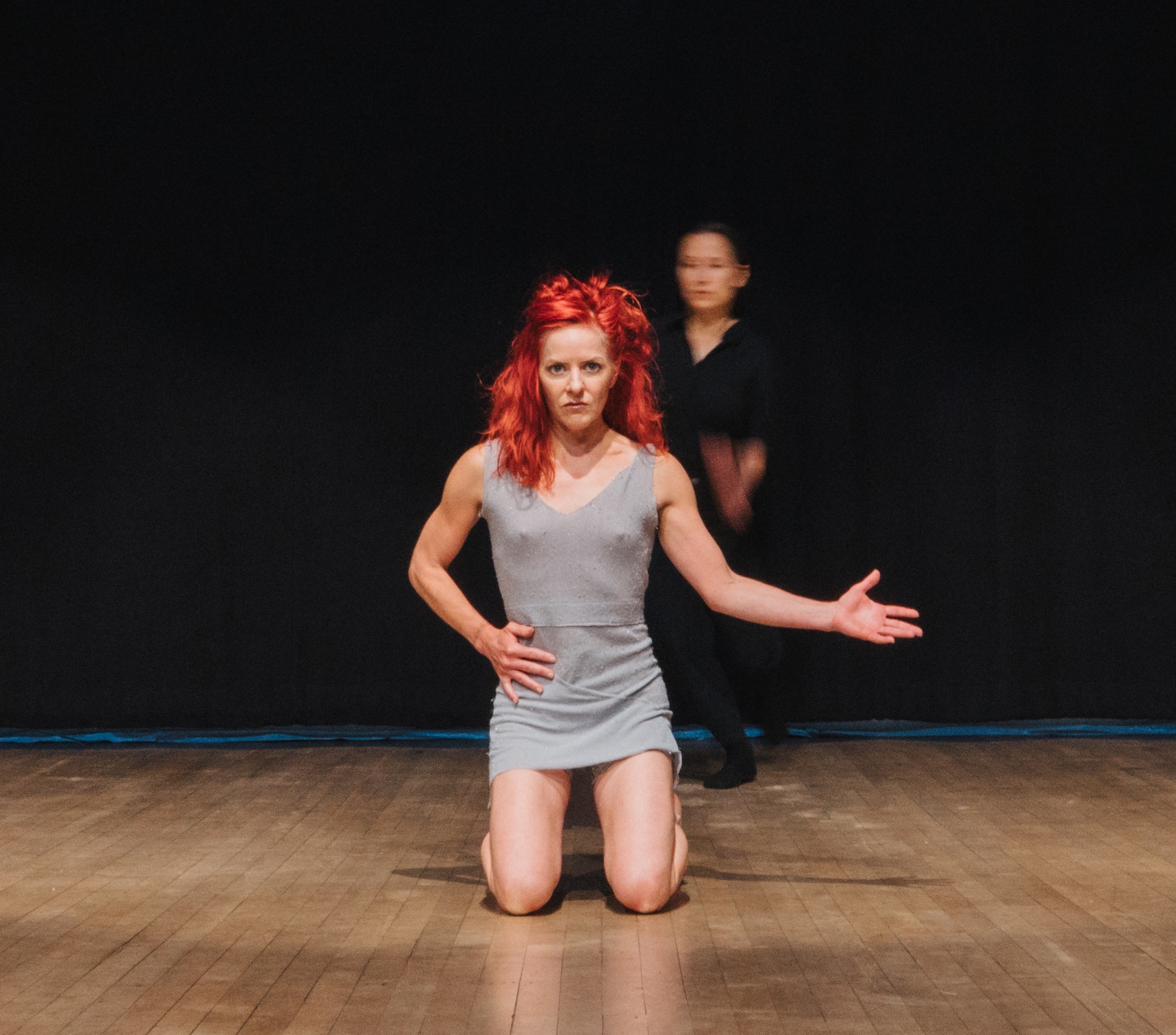 Dancer Shonshereé Giles is in the middle of the stage stares straight at the from a kneeling position