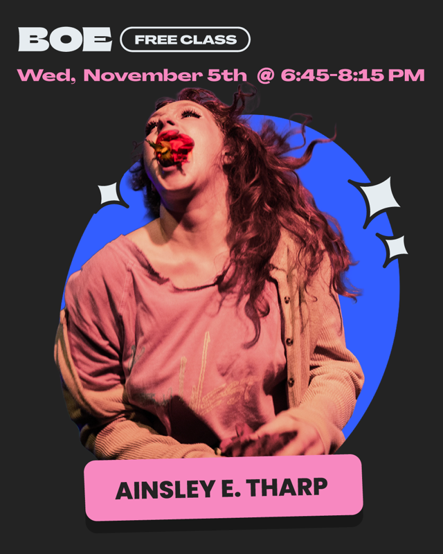 A white woman with long curly red hair is seen with a rose in her mouth. She is wearing a light red shirt with a beige cardigan.