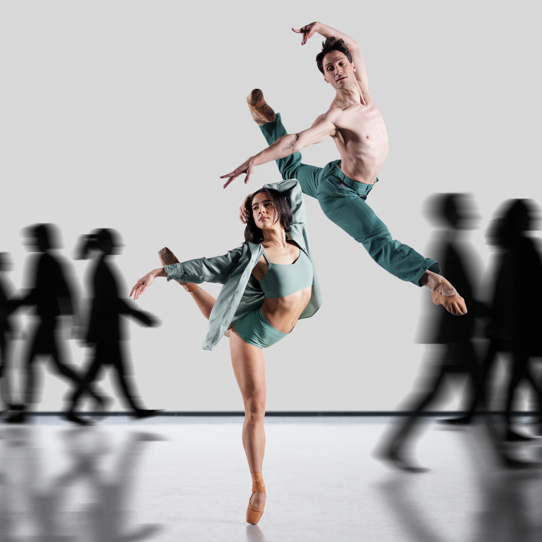 In the foreground, a woman wearing a mint green crop top, trunks, and unbuttoned shirt strikes a pose on pointe. Her left leg is raised behind her in attitude. One arms is extended to the side, and the other rests on her head. A man, wearing mint green jeans, jumps slightly behind and above her, mimicking her shape in the air. In the background, shadowed silhouettes walk facelessly along.