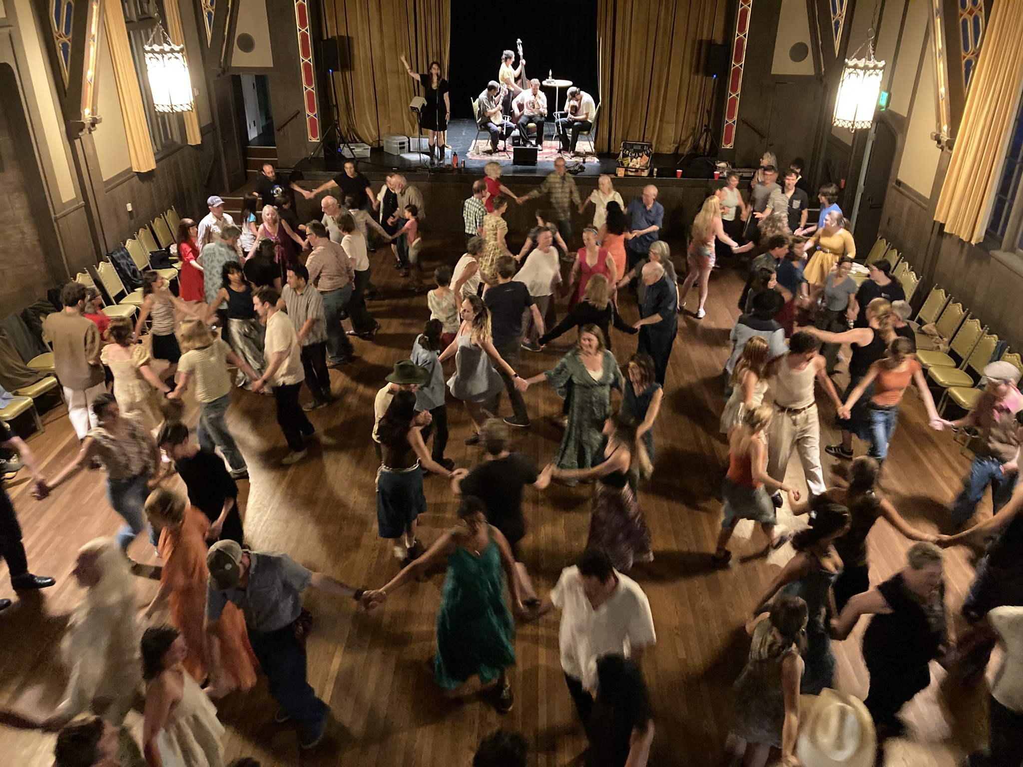 band on stage with fiddle, guitar, banjo, bass, and lots of dancers having fun.